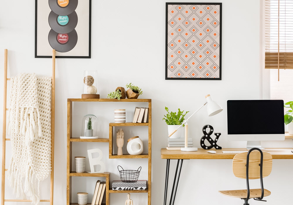 Organized apartment workspace with bookcase, desk, and computer. 