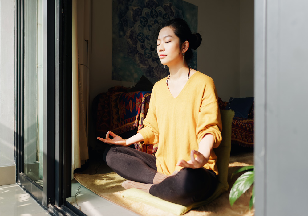 Woman meditating in front of open door