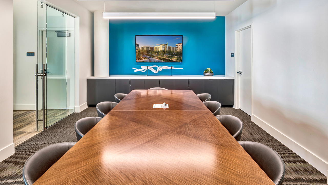 Modern Meeting Room with a long table, eight chairs, and a TV