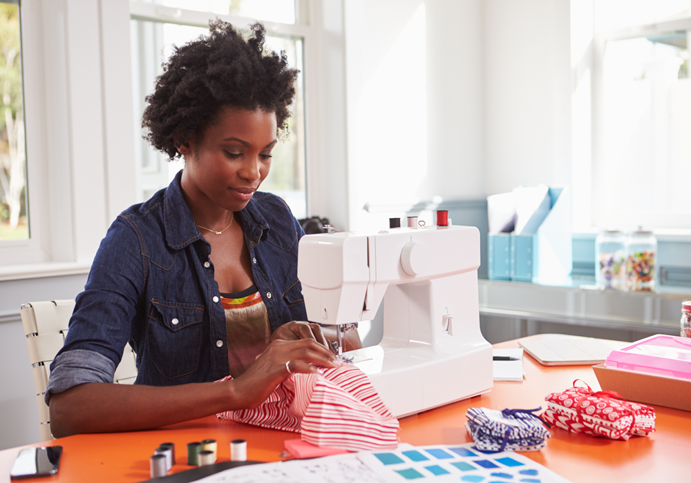 Woman learns to sew as a new hobby in her apartment home.