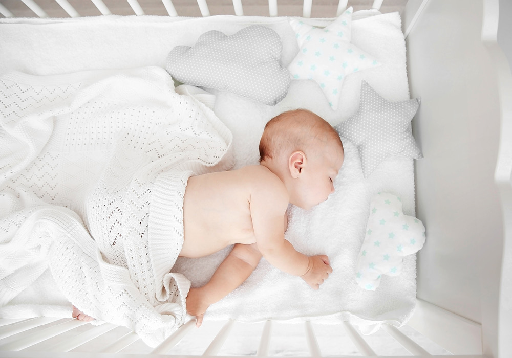 Baby sleeping in a white crib