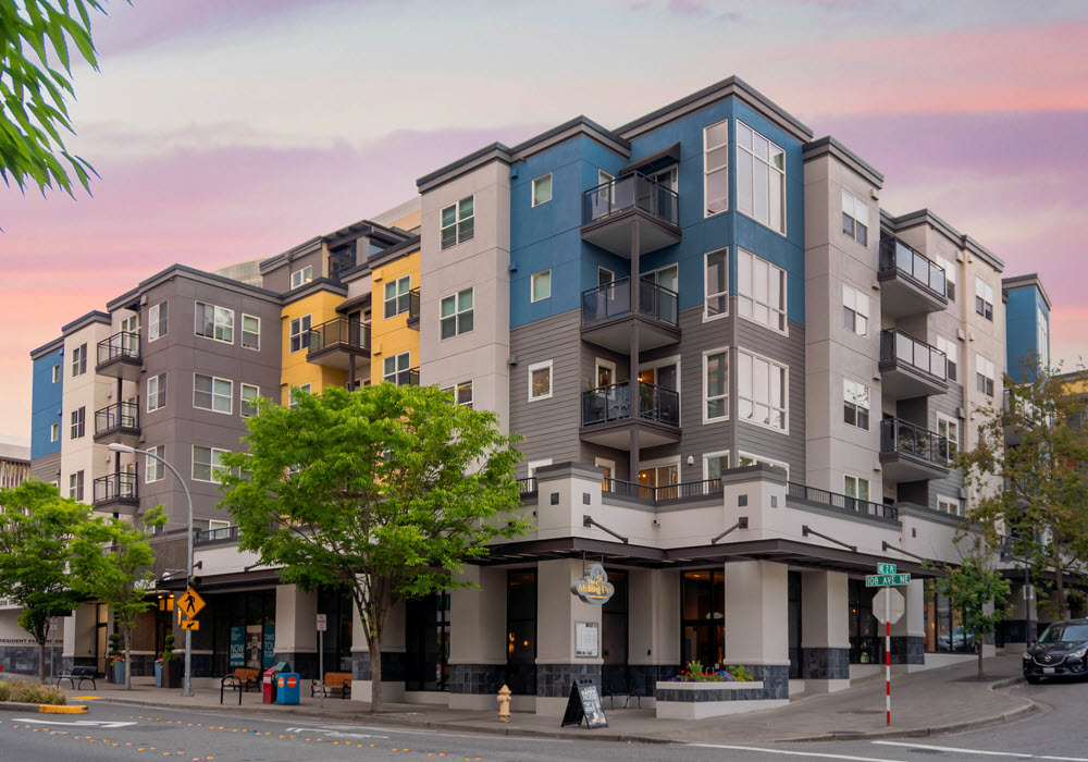 Exterior view of BellCentre Apartments in Seattle at dusk.