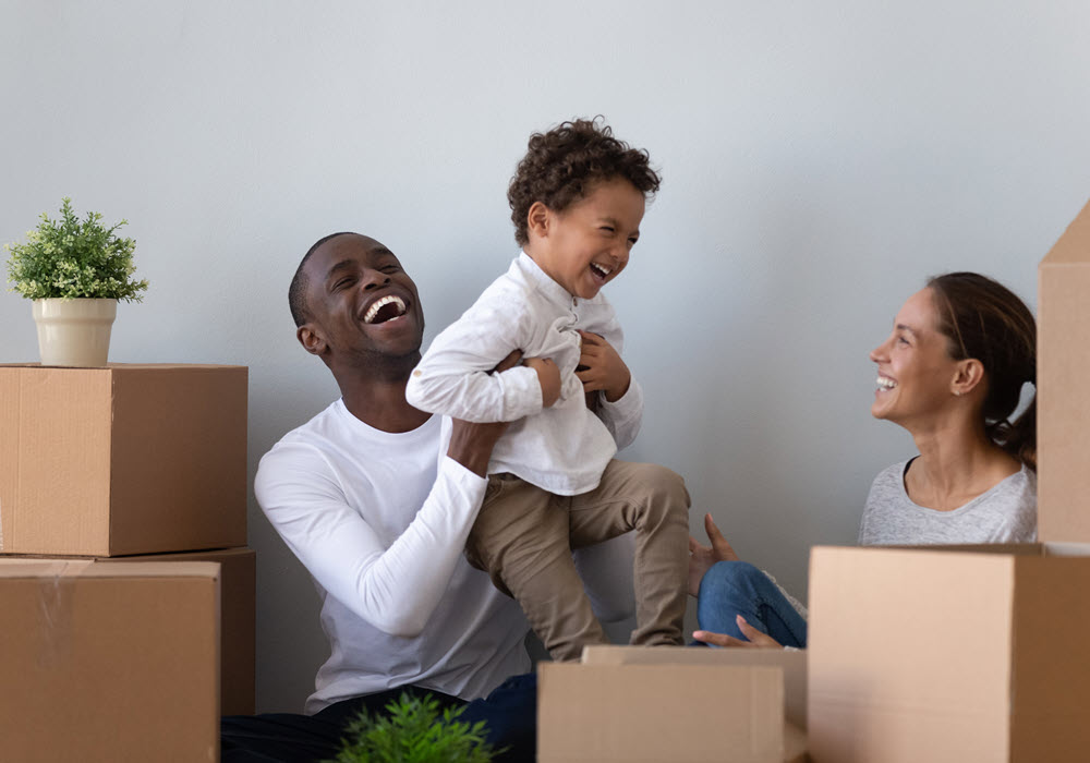 Family of 3 unboxing their moving boxes in their apartment home.