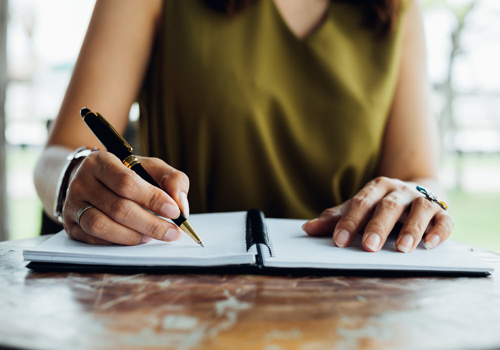 Woman writing a checklist in her notepad.