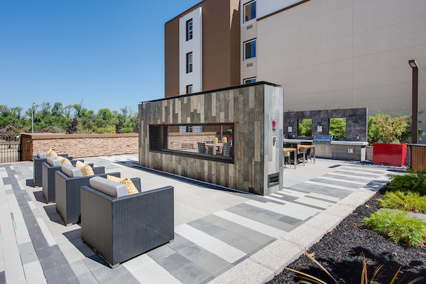 BBQ area with fireplace and lounge chairs.