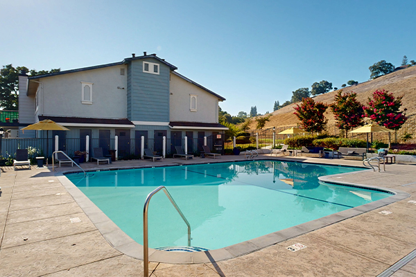 Outdoor swimming pool surrounded by lounge chairs.