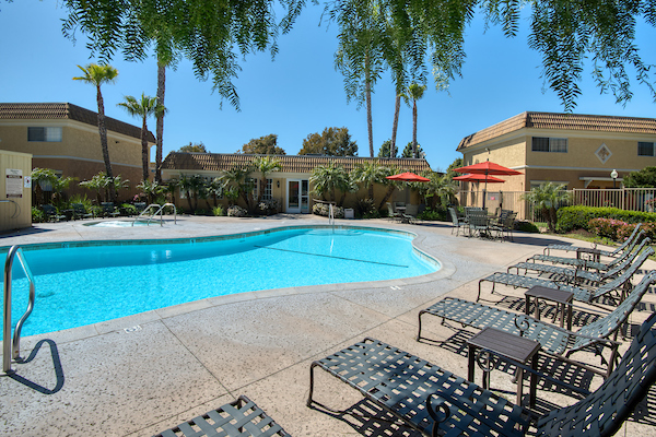 Outdoor swimming pool area with lounge seating and umbrellas.
