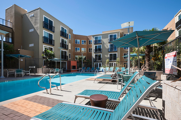 Outdoor swimming pool area with lounge seating and umbrellas.