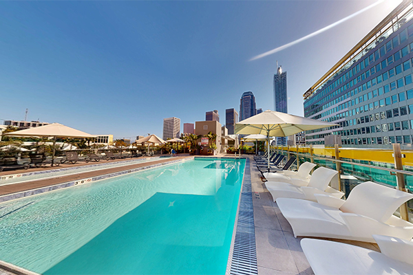 Rooftop swimming pool with lounge furniture.
