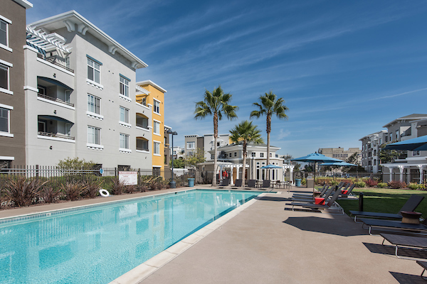 Outdoor swimming pool area with sundeck and lounge seating.